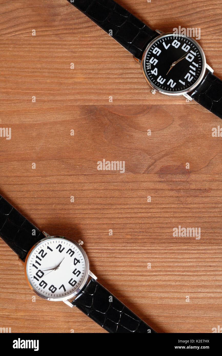 Paire de montres-bracelet noir et blanc moderne sur la surface en bois Banque D'Images