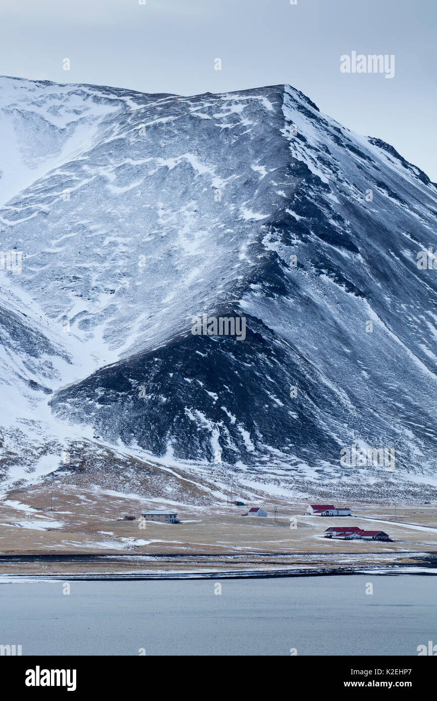 Ferme au pied de la péninsule de Snaefellsness Kolgrafamuli, enneigé, l'Islande, mars 2015. Banque D'Images