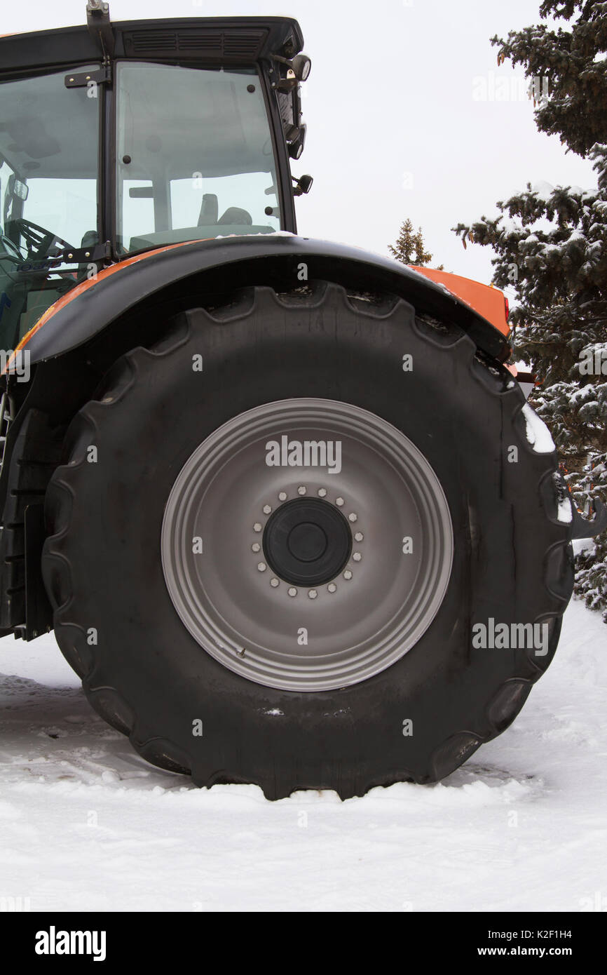 La roue d'un pneu de tracteur agricole à l'hiver sous la neige Photo Stock  - Alamy
