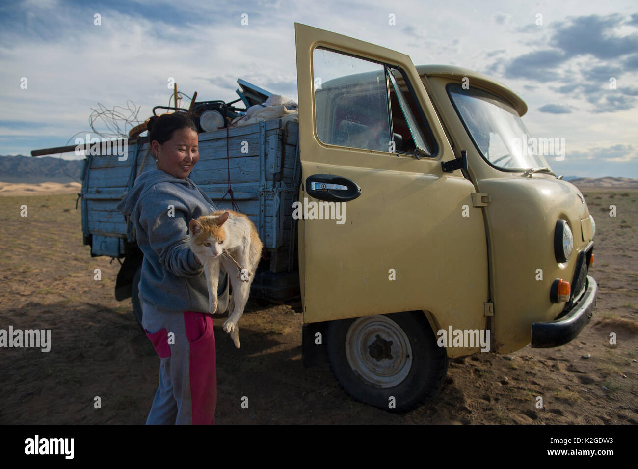 Famille nomade déménagement à summer place, chargement chat dans van, dunes de sable Khongor, Govi Gurvan Saikhan Parc National, désert de Gobi, la Mongolie du Sud. Juin 2015. Banque D'Images