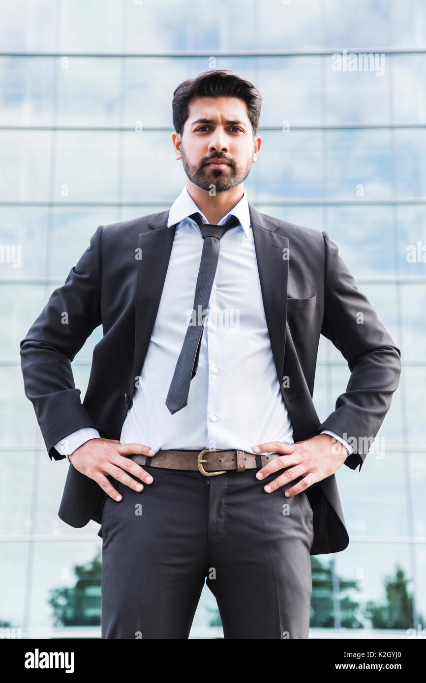 L'arabe serious businessman ou travailleur en costume noir avec une cravate  et chemise avec barbe, debout devant un immeuble de bureaux sur l'herbe  verte en été 24 Photo Stock - Alamy
