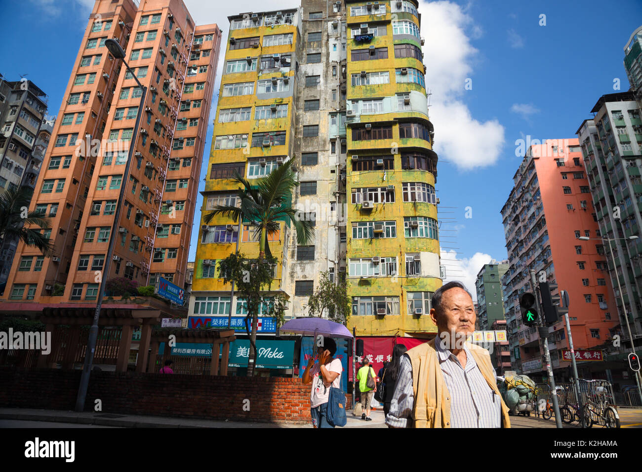 Un homme marche dans les rues de Kowloon avec bâtiments typiques, Hong Kong Banque D'Images