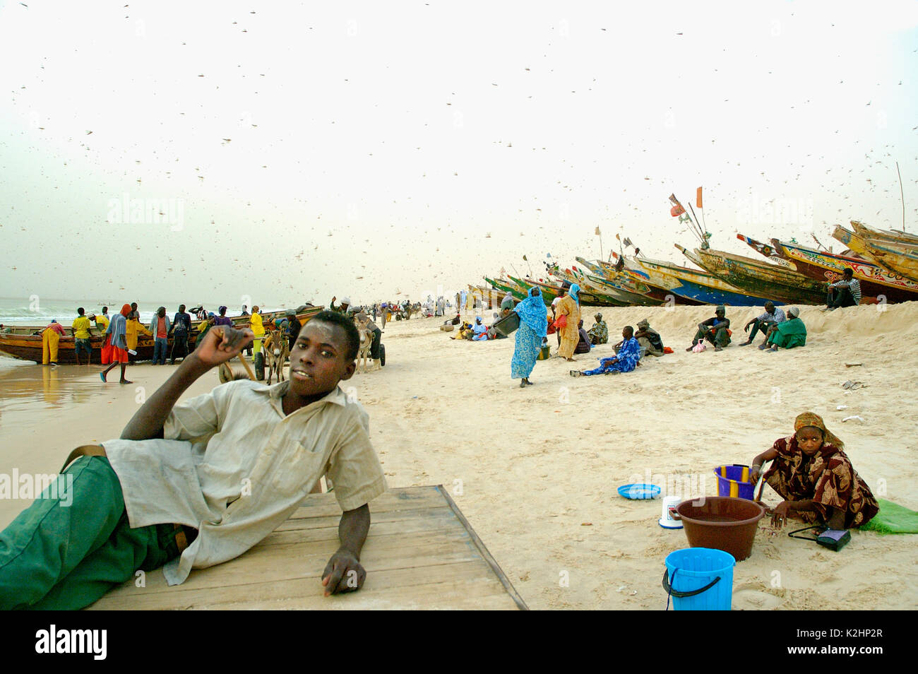 Les vendeurs de poissons attendent les bateaux de pêche sur la plage à Nouakchott, Mauritanie Banque D'Images