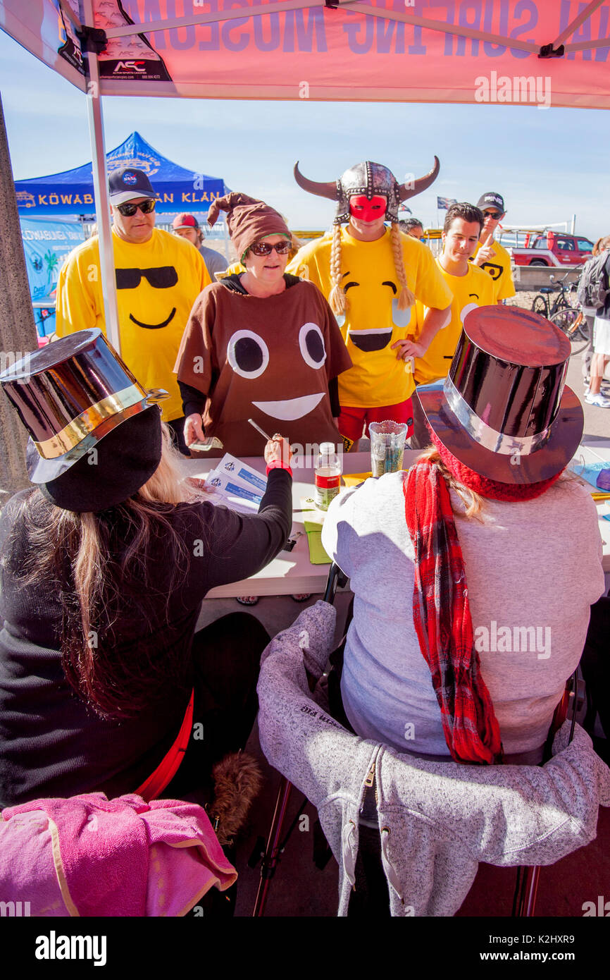 Portant des costumes extravagants, les nageurs présentent plus à un jour de la ville de 'SURF' Splash plongez dans l'océan Huntington Beach, CA. Banque D'Images