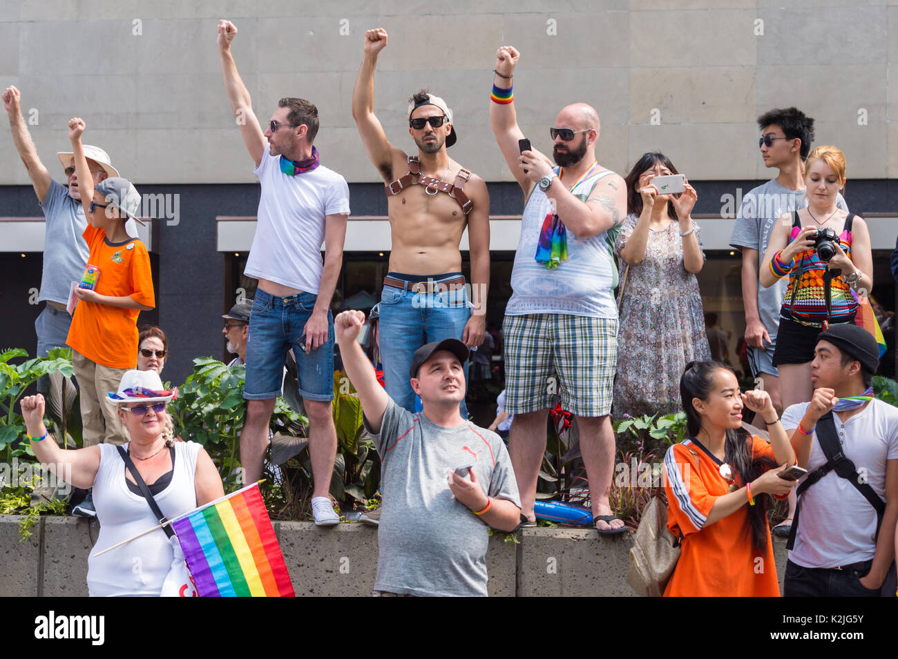 Montréal, Canada - 20 août 2017 : spectateurs lever leurs poings lors de moment de silence à la parade de la Fierté gaie de Montréal. Banque D'Images