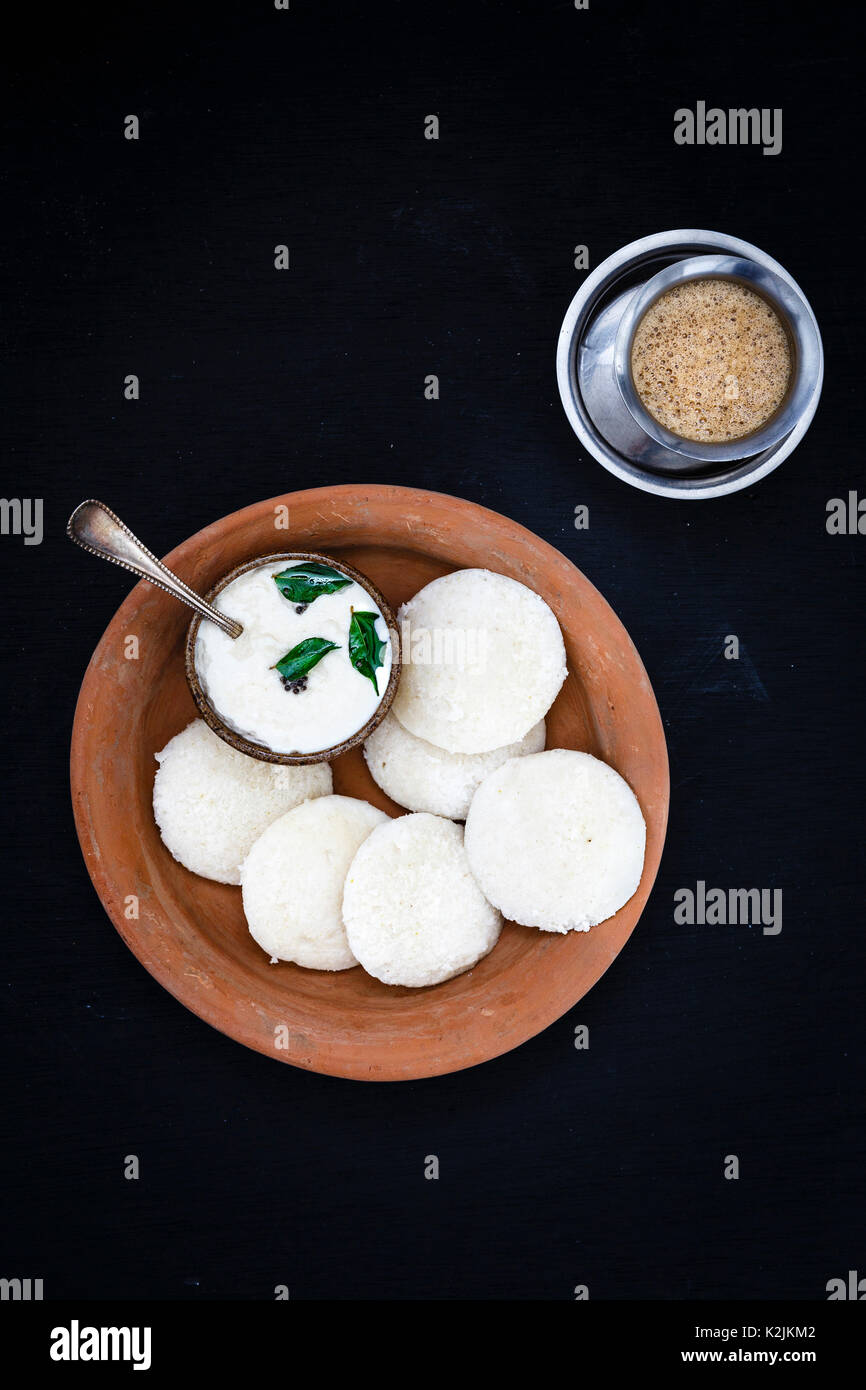 Un petit-déjeuner traditionnel indien du sud de l'Inde à la vapeur douce sans rien faire (Idli / gâteau de riz) servi avec un chutney de noix de coco et le café filtre Banque D'Images