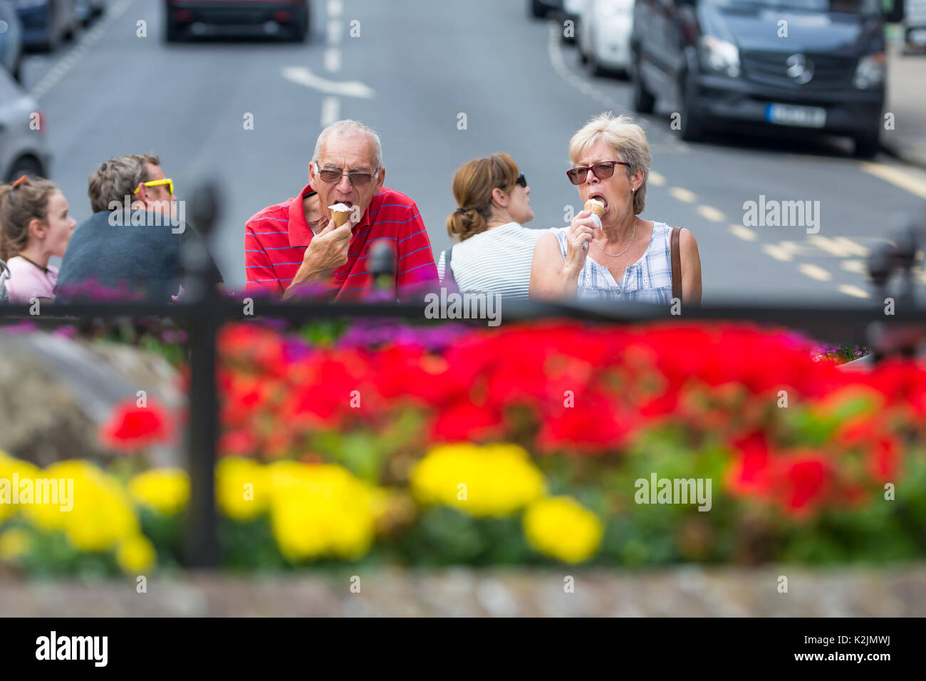 Couple d'âge moyen de manger des glaces en été dans le Royaume-Uni. Banque D'Images