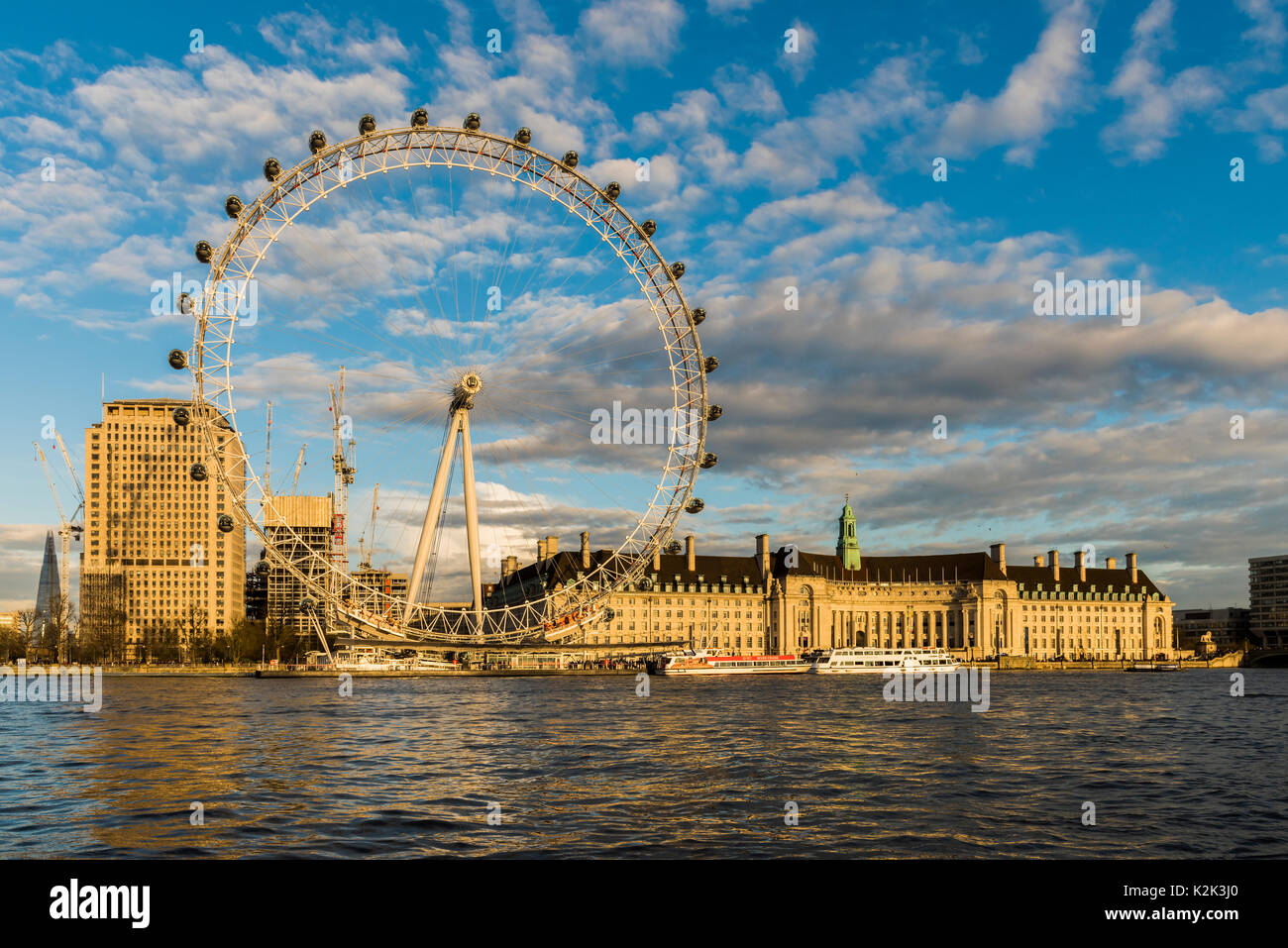 London's Southbank glourious baigné de soleil du printemps alors que le soleil se couche sur la Tamise. Le London Eye, l'aquarium et bâtiment shell peut être vu. Banque D'Images