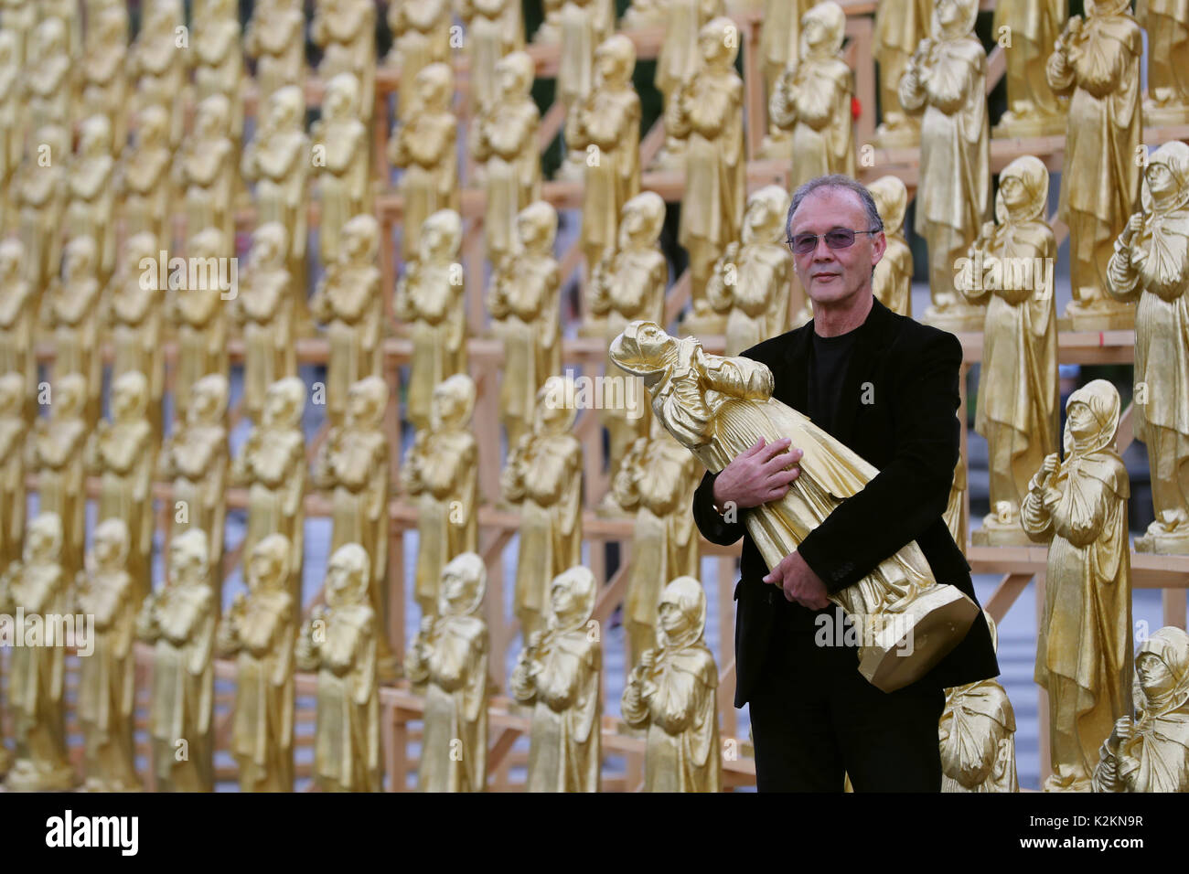 Nuremberg, Allemagne. Du 1er septembre 2017. Le concept artiste Ottmar Hoerl se tient entre golden Madonna figurines à Nuremberg, Allemagne, 1 septembre 2017. Hoerl's art performance avec 600 golden Madonna chiffres sur une plateforme de 80 mètres de longueur s'affiche pendant deux semaines en avant de la Musée national germanique. Photo : Daniel Karmann/dpa/Alamy Live News Banque D'Images
