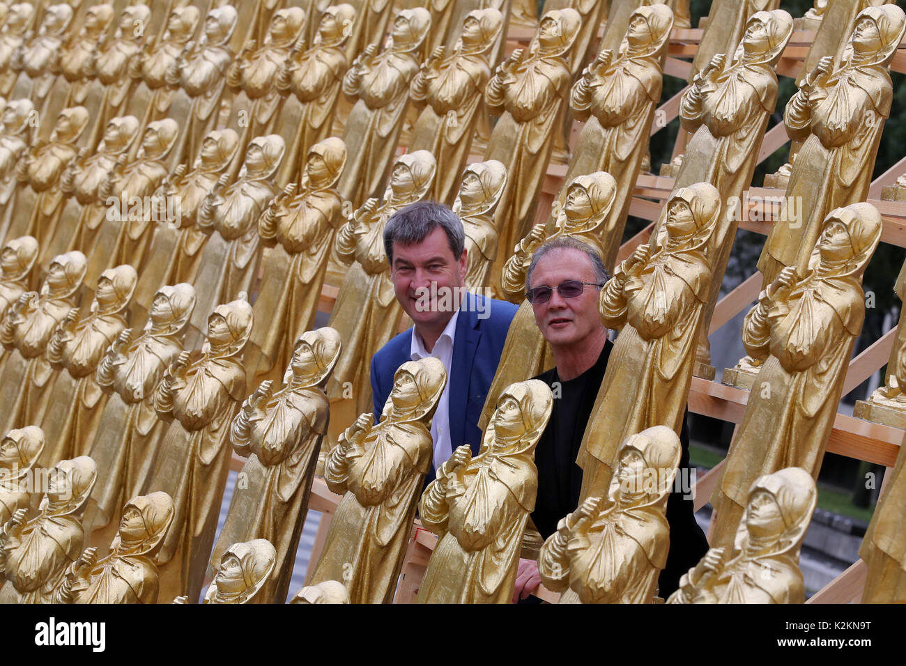 Nuremberg, Allemagne. Du 1er septembre 2017. Le concept artiste Ottmar Hoerl (R) et le ministre bavarois de l'origine étrangères Markus Soeder se tenir entre golden Madonna figurines à Nuremberg, Allemagne, 1 septembre 2017. Hoerl's art performance avec 600 golden Madonna chiffres sur une plateforme de 80 mètres de longueur s'affiche pendant deux semaines en avant de la Musée national germanique. Photo : Daniel Karmann/dpa/Alamy Live News Banque D'Images