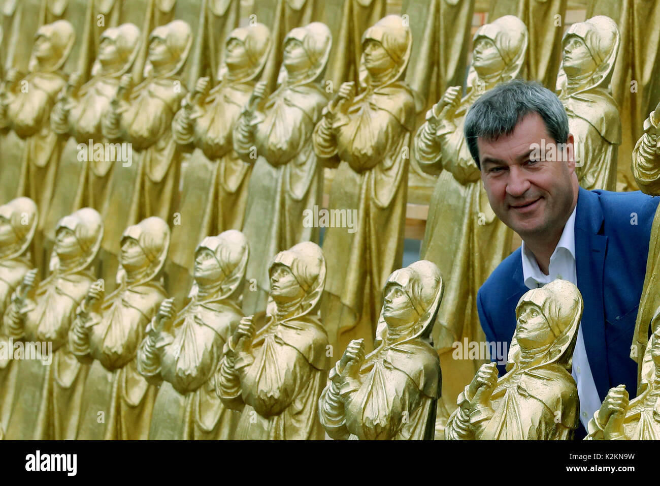 Nuremberg, Allemagne. Du 1er septembre 2017. Le ministre bavarois de l'origine étrangères Markus Soeder se tient entre golden Madonna figurines à Nuremberg, Allemagne, 1 septembre 2017. Hoerl's art performance avec 600 golden Madonna chiffres sur une plateforme de 80 mètres de longueur s'affiche pendant deux semaines en avant de la Musée national germanique. Photo : Daniel Karmann/dpa/Alamy Live News Banque D'Images