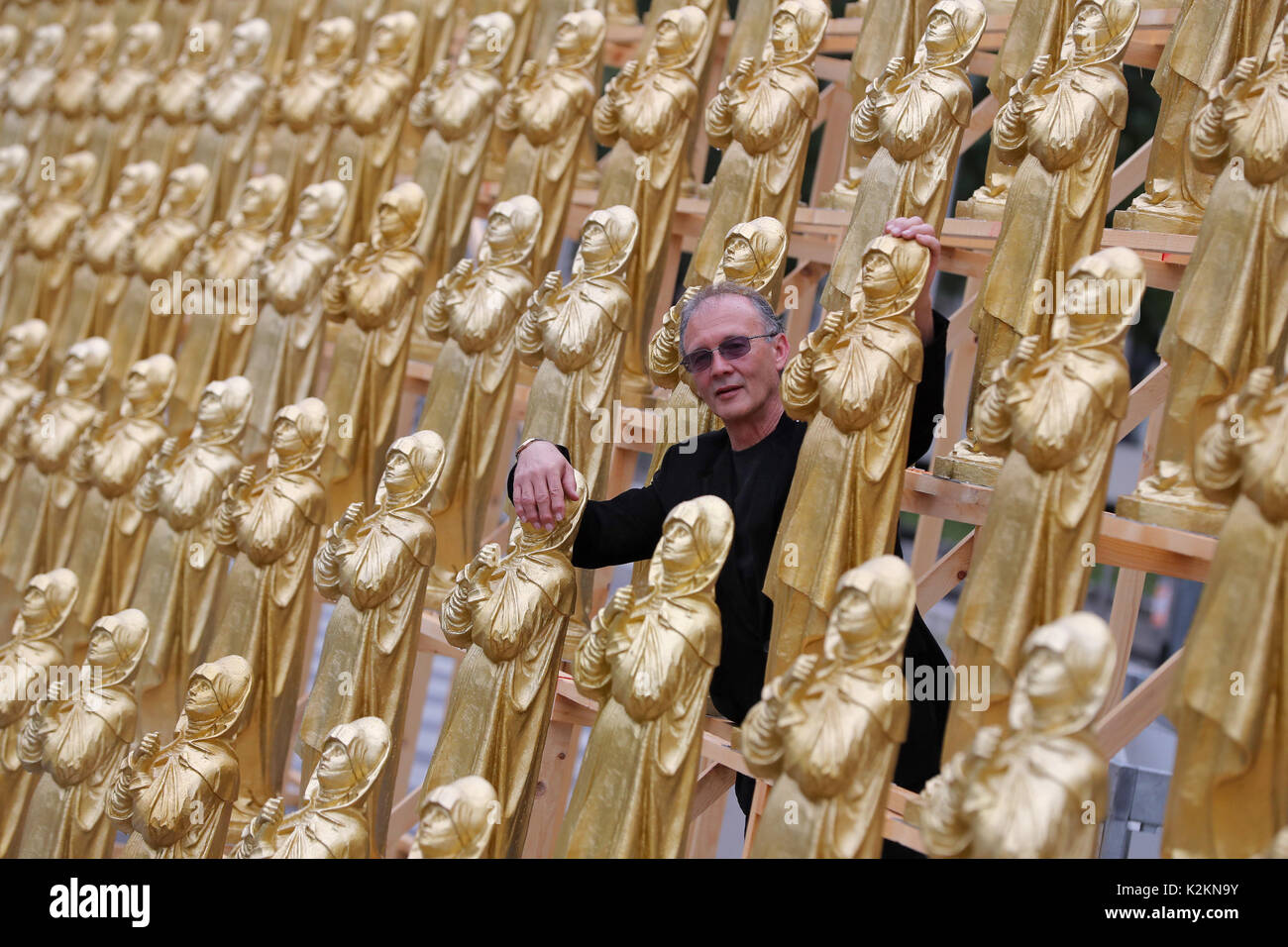 Nuremberg, Allemagne. Du 1er septembre 2017. Le concept artiste Ottmar Hoerl se tient entre golden Madonna figurines à Nuremberg, Allemagne, 1 septembre 2017. Hoerl's art performance avec 600 golden Madonna chiffres sur une plateforme de 80 mètres de longueur s'affiche pendant deux semaines en avant de la Musée national germanique. Photo : Daniel Karmann/dpa/Alamy Live News Banque D'Images