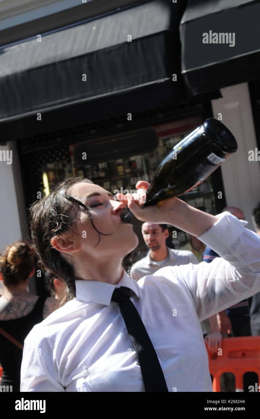 Une serveuse de boire du champagne, après la course des garçons de Soho. Banque D'Images