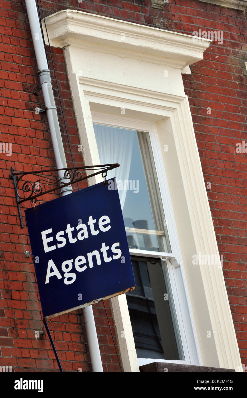 Une agence immobilière sign en dehors d'un style victorien ou bâtiment édouardien à côté d'une fenêtre sur un cadre en fonte du patrimoine traditionnel signes annoncés Banque D'Images