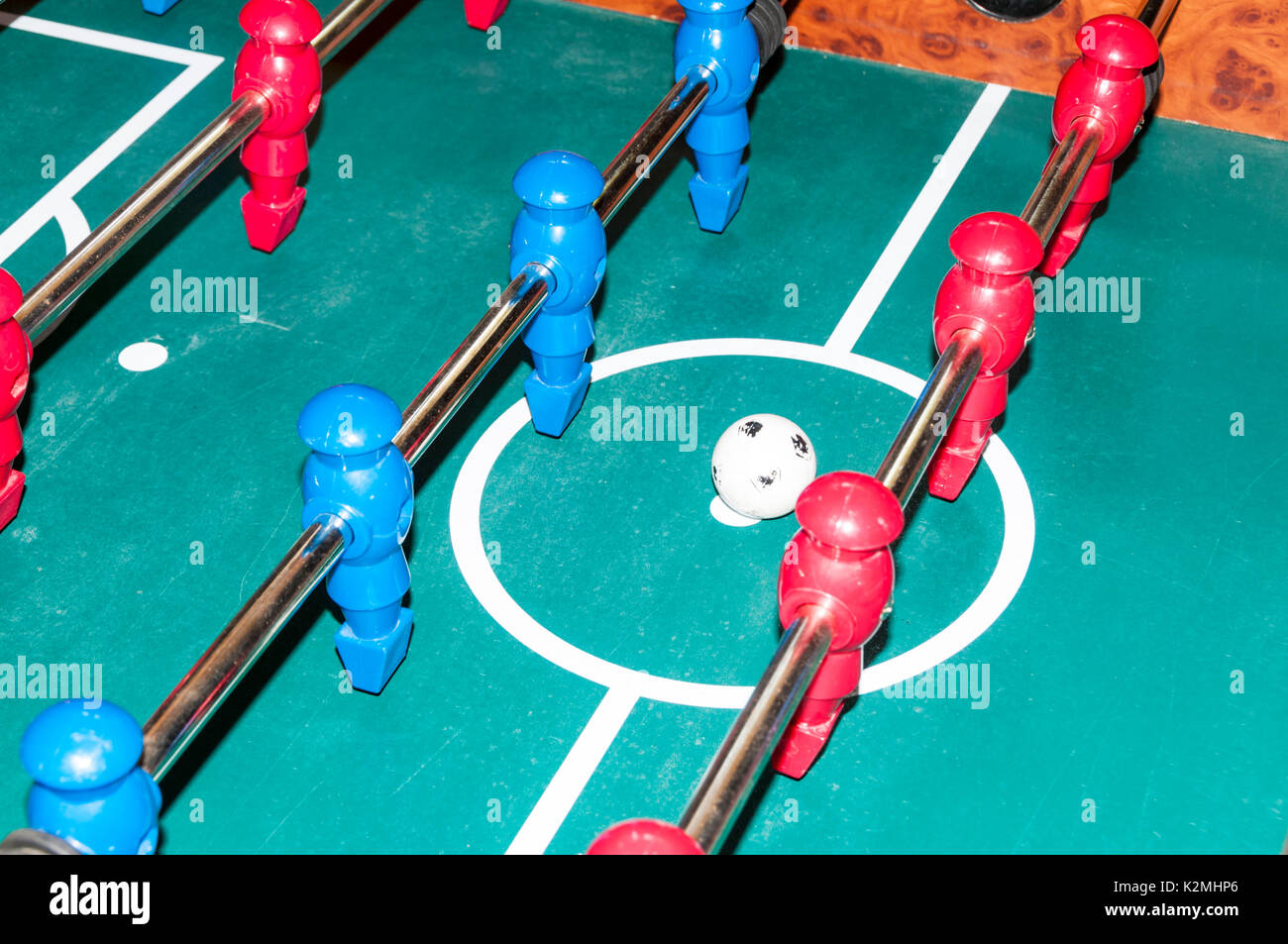 Les équipes rouge et bleu pour le coup d'envoi dans un jeu de baby-foot Banque D'Images