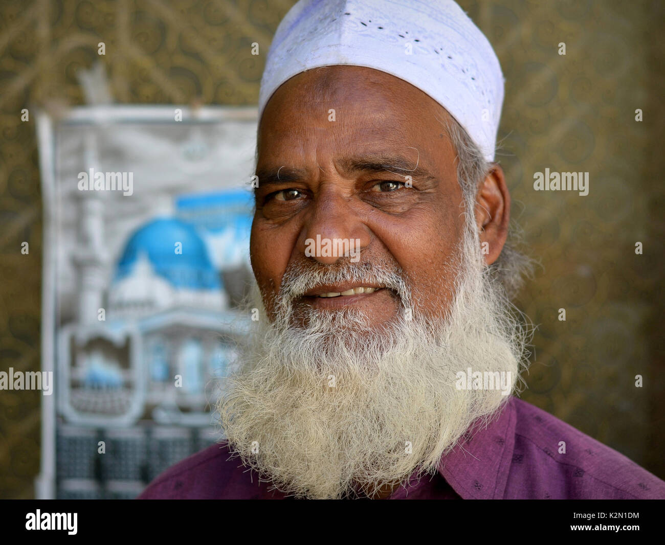 Imam d'une communauté musulmane avec barbe islamique et grande bosse de prière sur son front (zebibah) porte une casquette de prière (taqiyah) et pose pour la caméra. Banque D'Images
