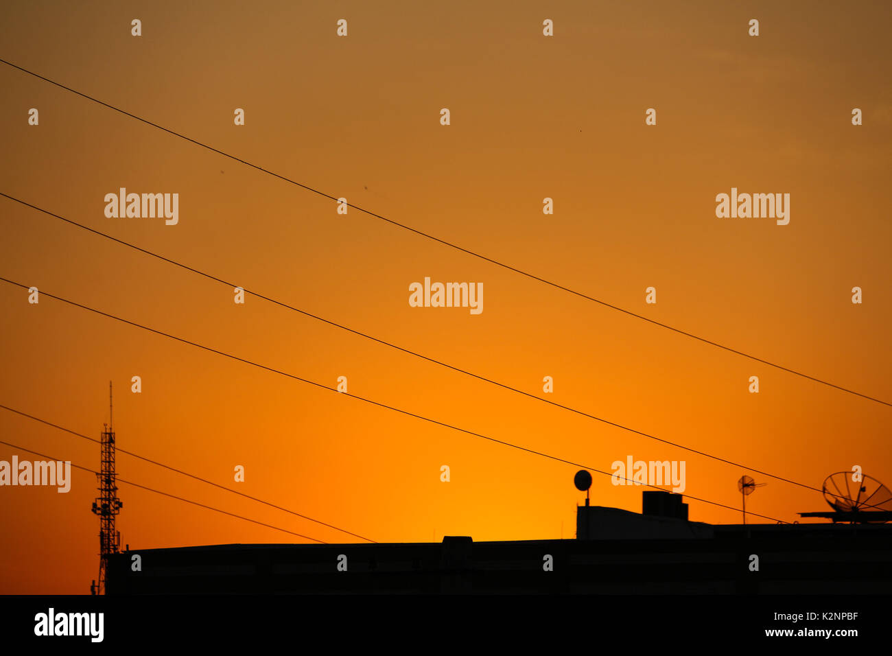 Vue de ciel orange avec des antennes de télécommunications pendant le coucher du soleil dans le quartier de Madureira, dans la ville de Rio de Janeiro, Brésil. Banque D'Images