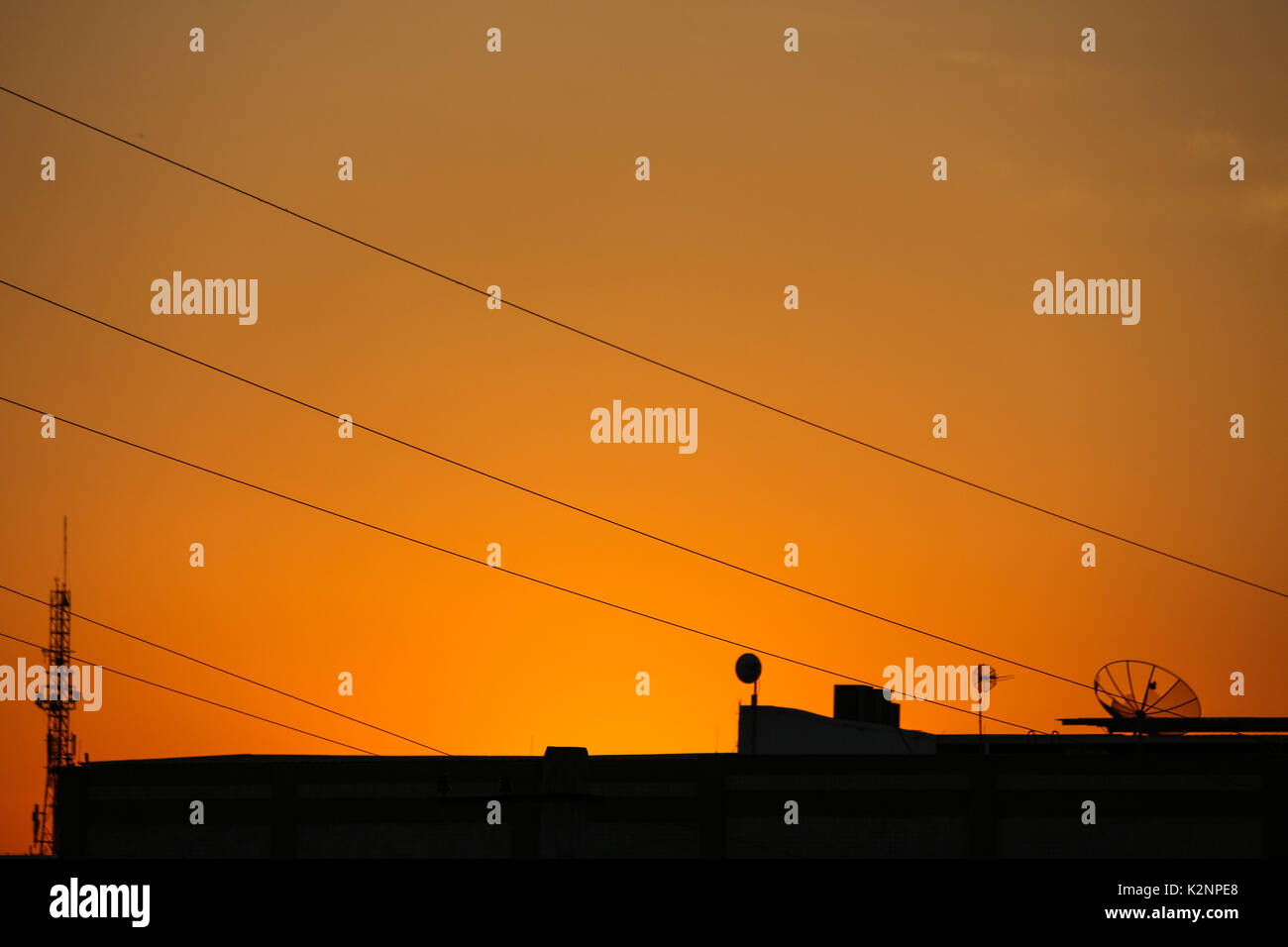Vue de ciel orange avec des antennes de télécommunications pendant le coucher du soleil dans le quartier de Madureira, dans la ville de Rio de Janeiro, Brésil. Banque D'Images