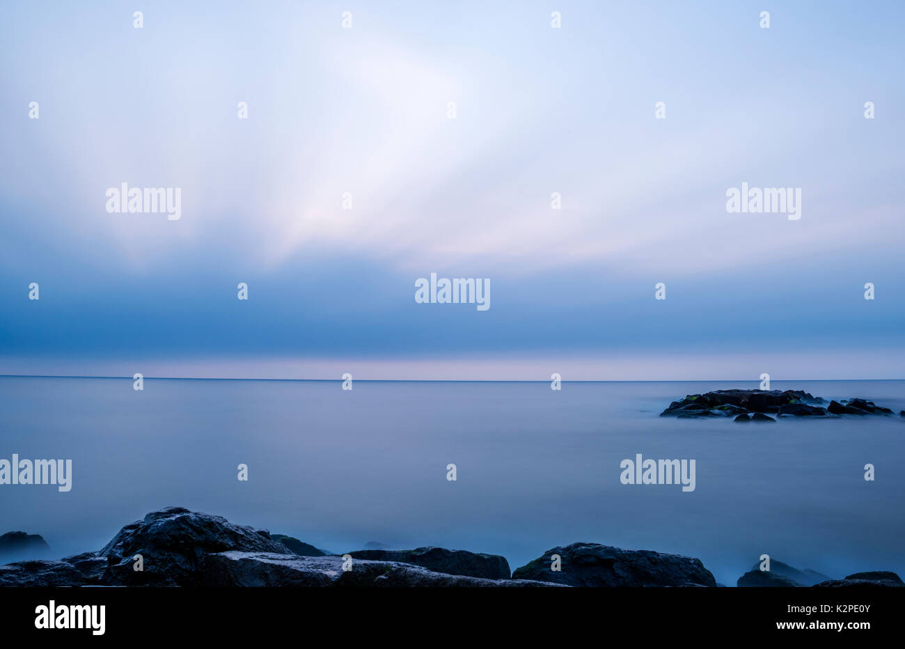 Longue Exposition de fond de l'océan, avec ciel nuageux sur l'arrière-plan au cours d'une heure bleue. Photo a été prise à Asbury Park, New Jersey Banque D'Images