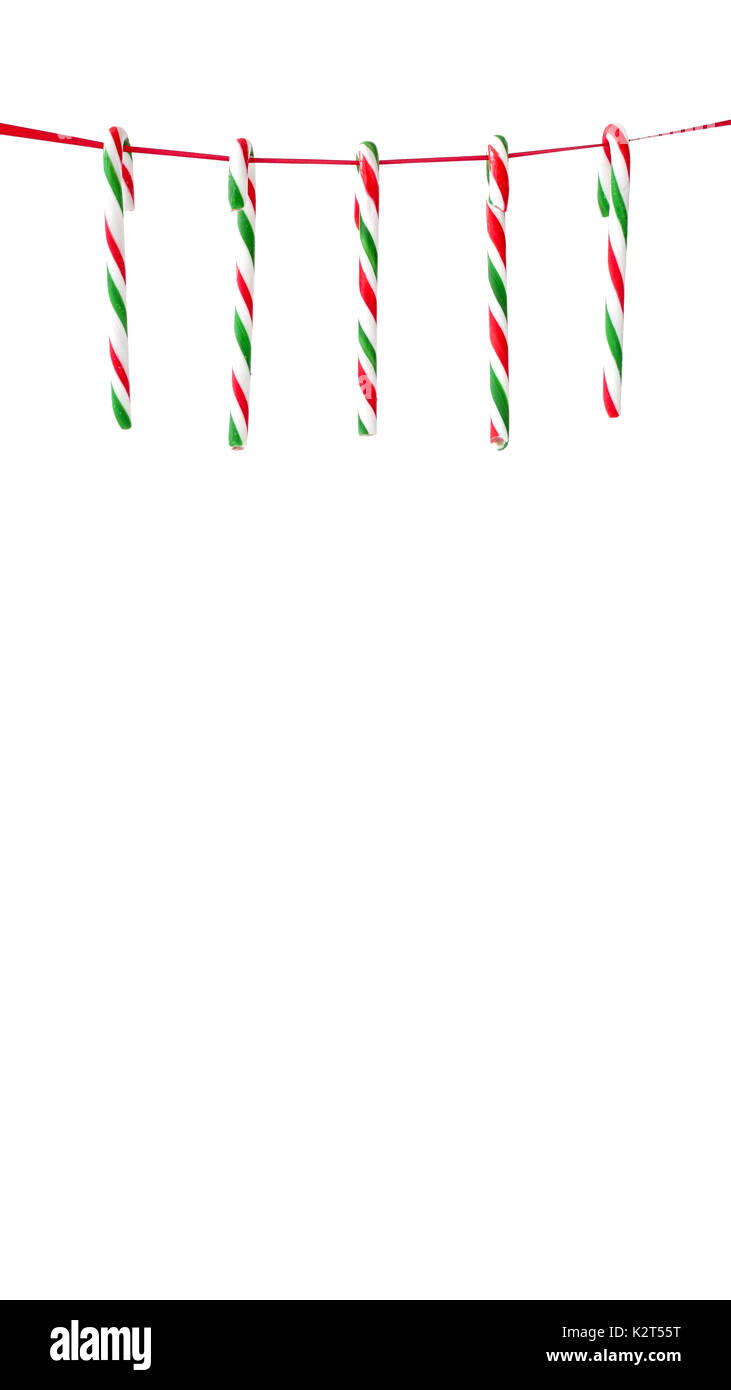 Cinq rayures rouges et verts des cannes de bonbon suspendu à un ruban rouge comme décoration de Noël. Banque D'Images