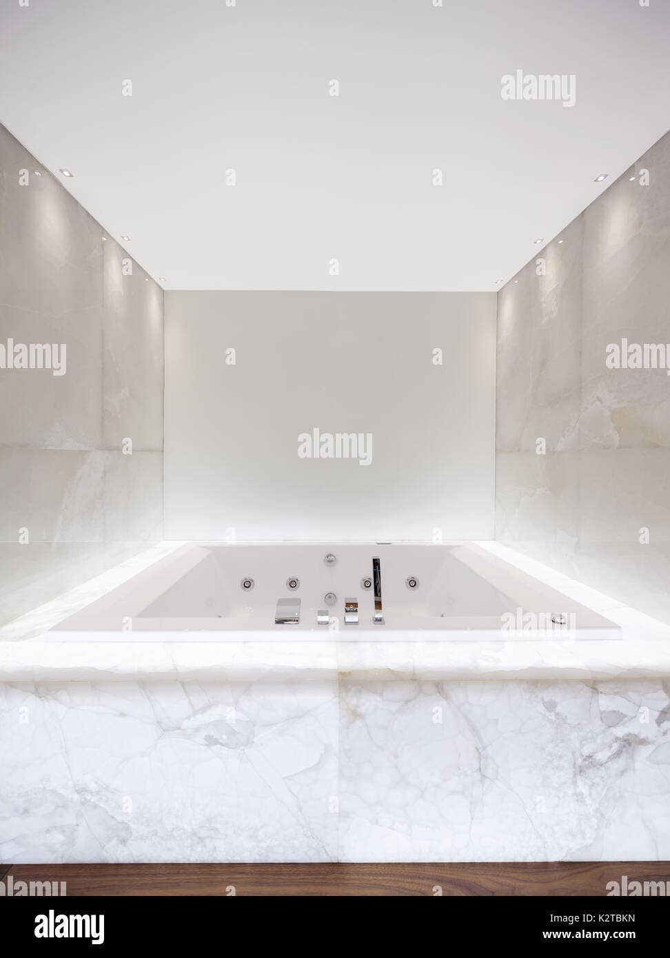 Grande baignoire à remous dans la salle de bain éclairée en Banque D'Images