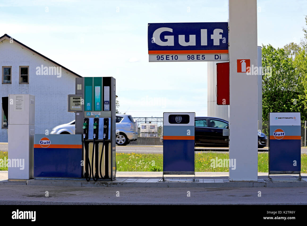 MIETOINEN, FINLANDE - le 3 juin 2017 : les pompes à carburant à l'essence sans pilote du golfe en Mietoinen station de charge sur une journée ensoleillée de l'été avec des voitures à la vitesse sur l'hi Banque D'Images