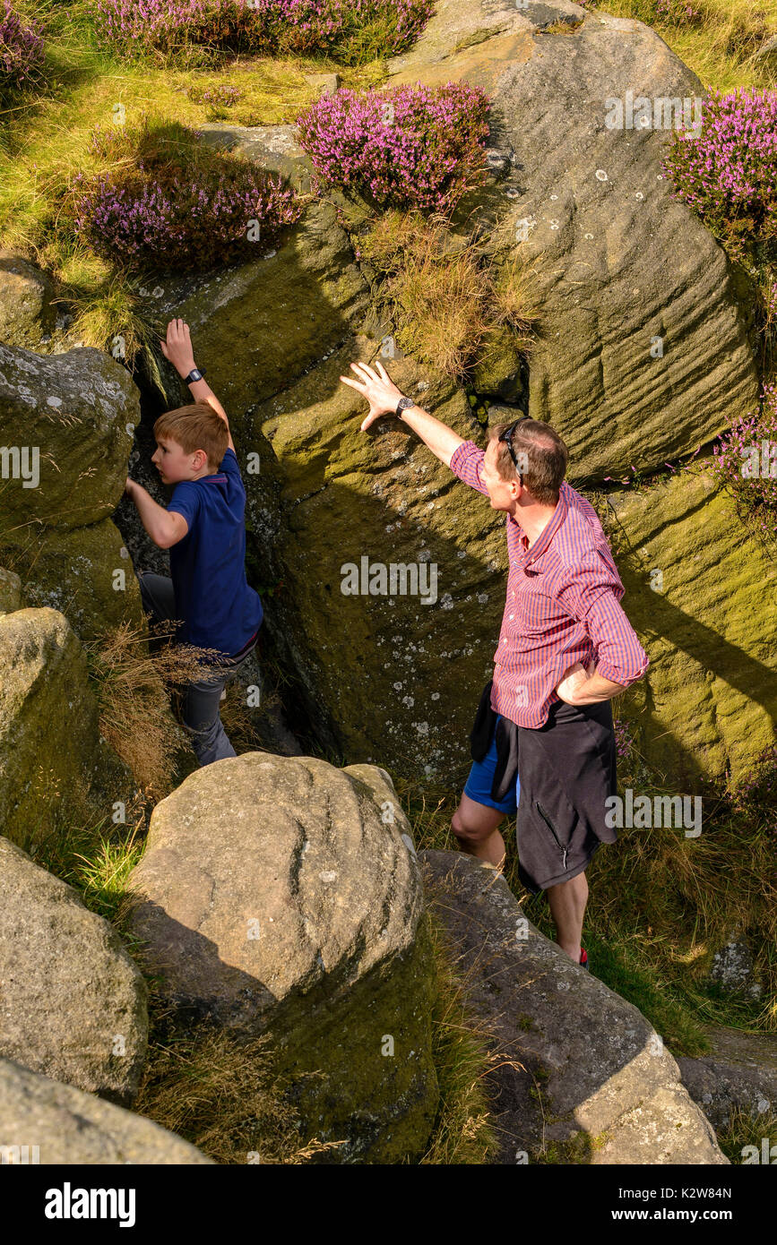 Family fun scambling des roches sur le Yorkshire Moors Banque D'Images