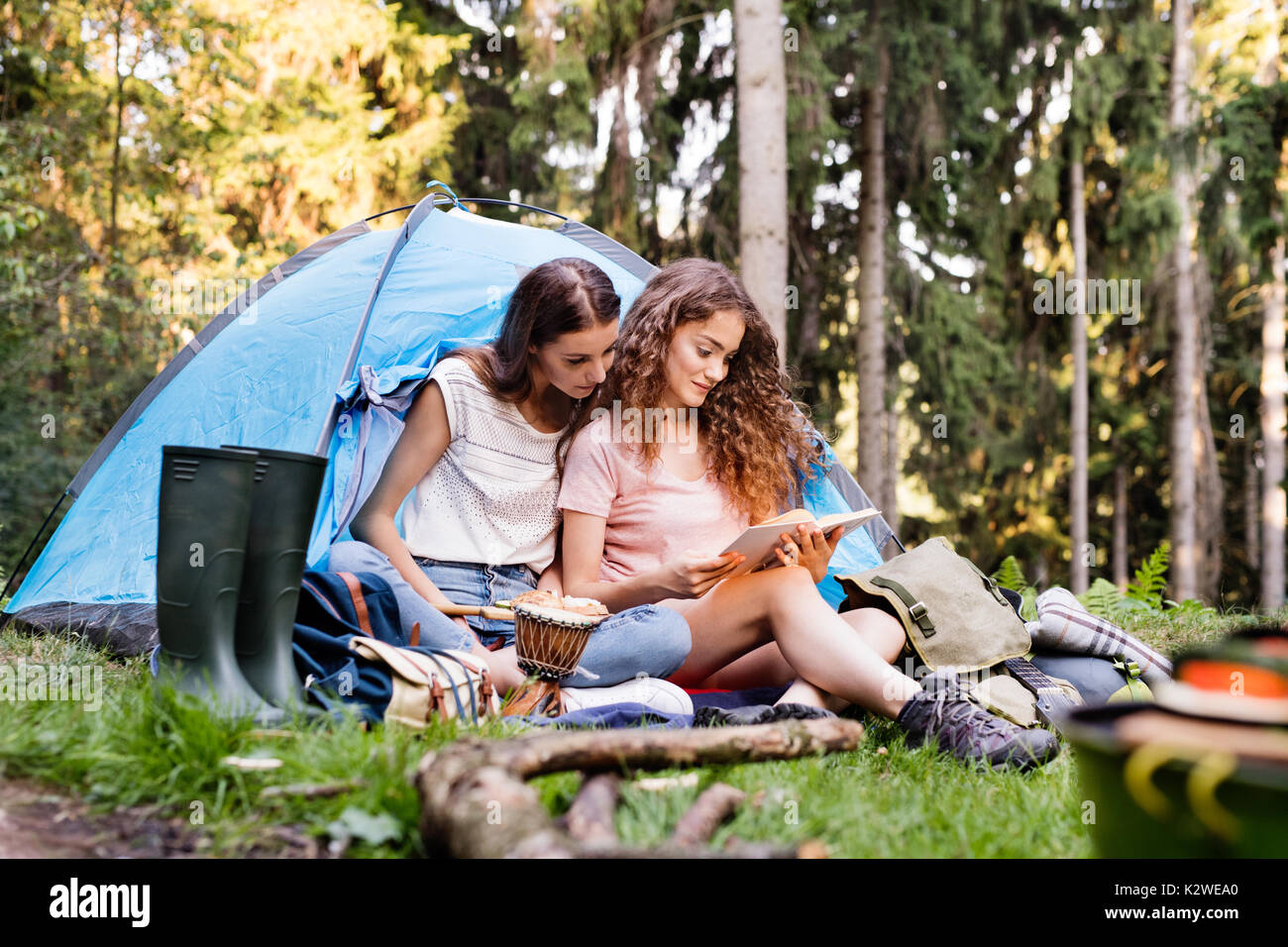 Adolescente en face de la tente du camping en forêt. Banque D'Images