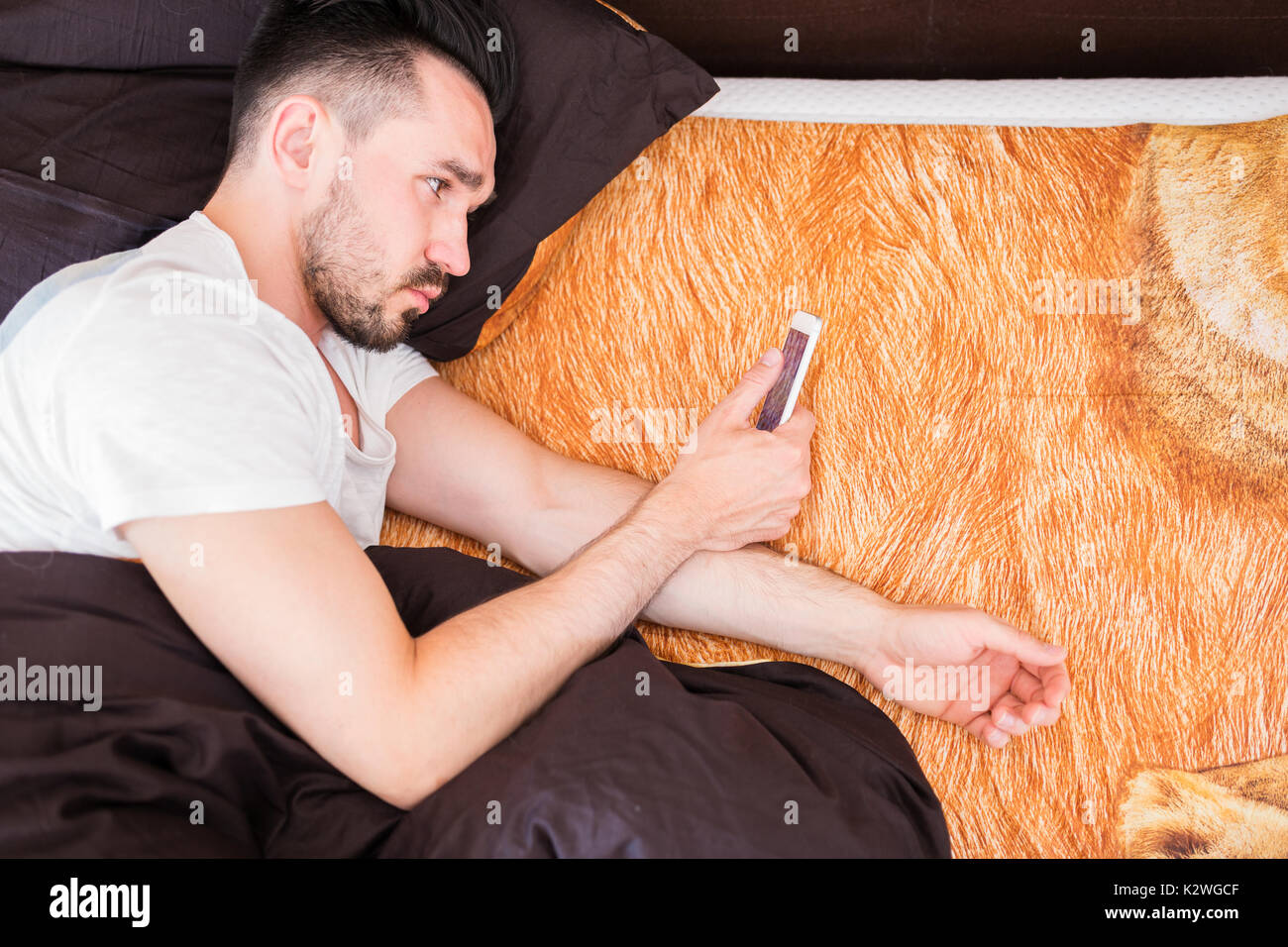 Mansurfing le net sur son smart phone in bed Banque D'Images