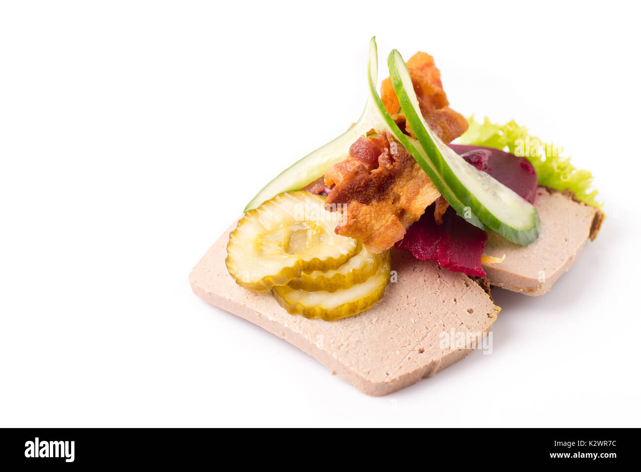 Des plats nationaux et des spécialités danoises, sandwich ouvert de grande qualité, le pâté de foie avec du bacon, betterave cornichon et concombre isolated on white ba Banque D'Images