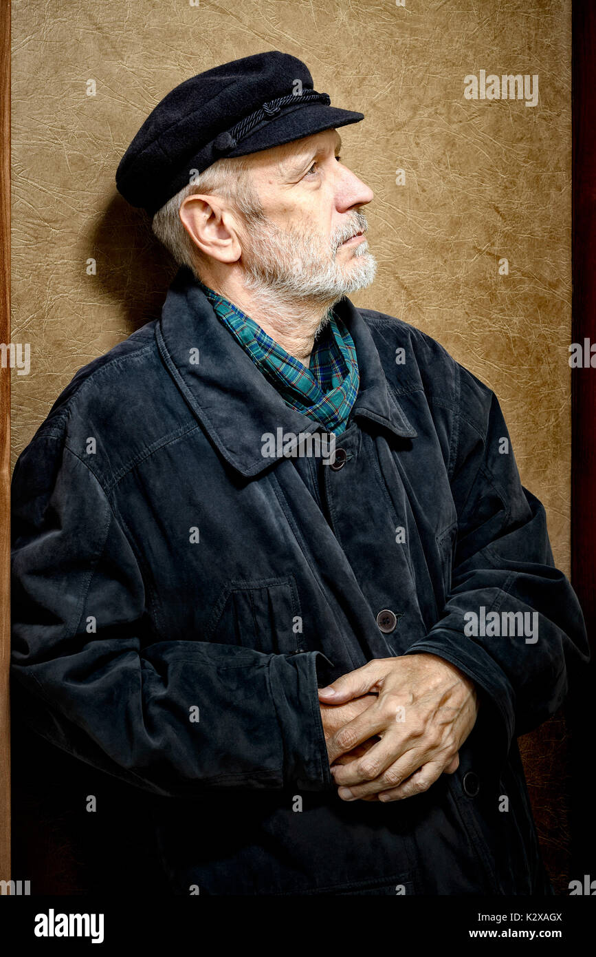 Portrait d'un homme mûr avec une barbe blanche et un chapeau sur la tête. Il pourrait être un marin, un travailleur, un docker, ou même d'un bandit ou d'un voyou. Il est looki Banque D'Images
