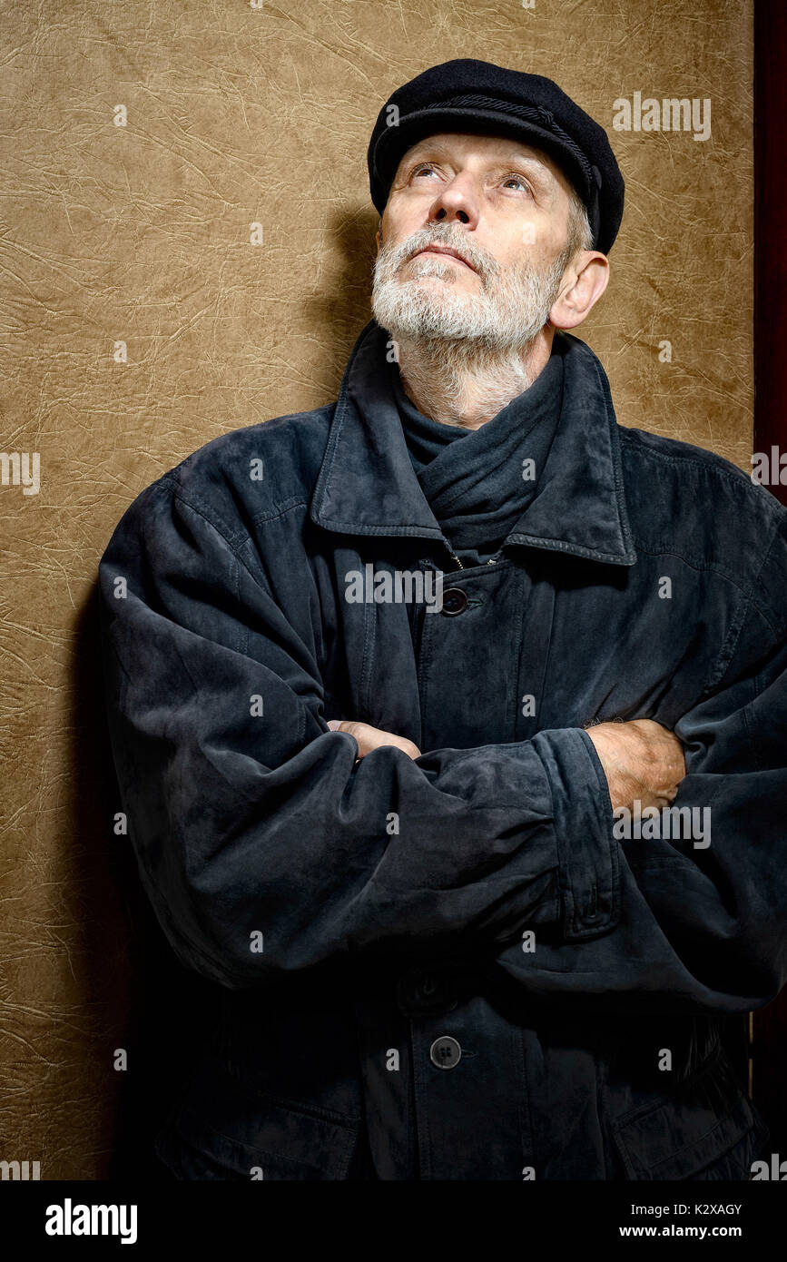 Portrait d'un homme mûr avec une barbe blanche et un chapeau sur la tête. Il pourrait être un marin, un travailleur, un docker, ou même d'un bandit ou d'un voyou. Il est looki Banque D'Images