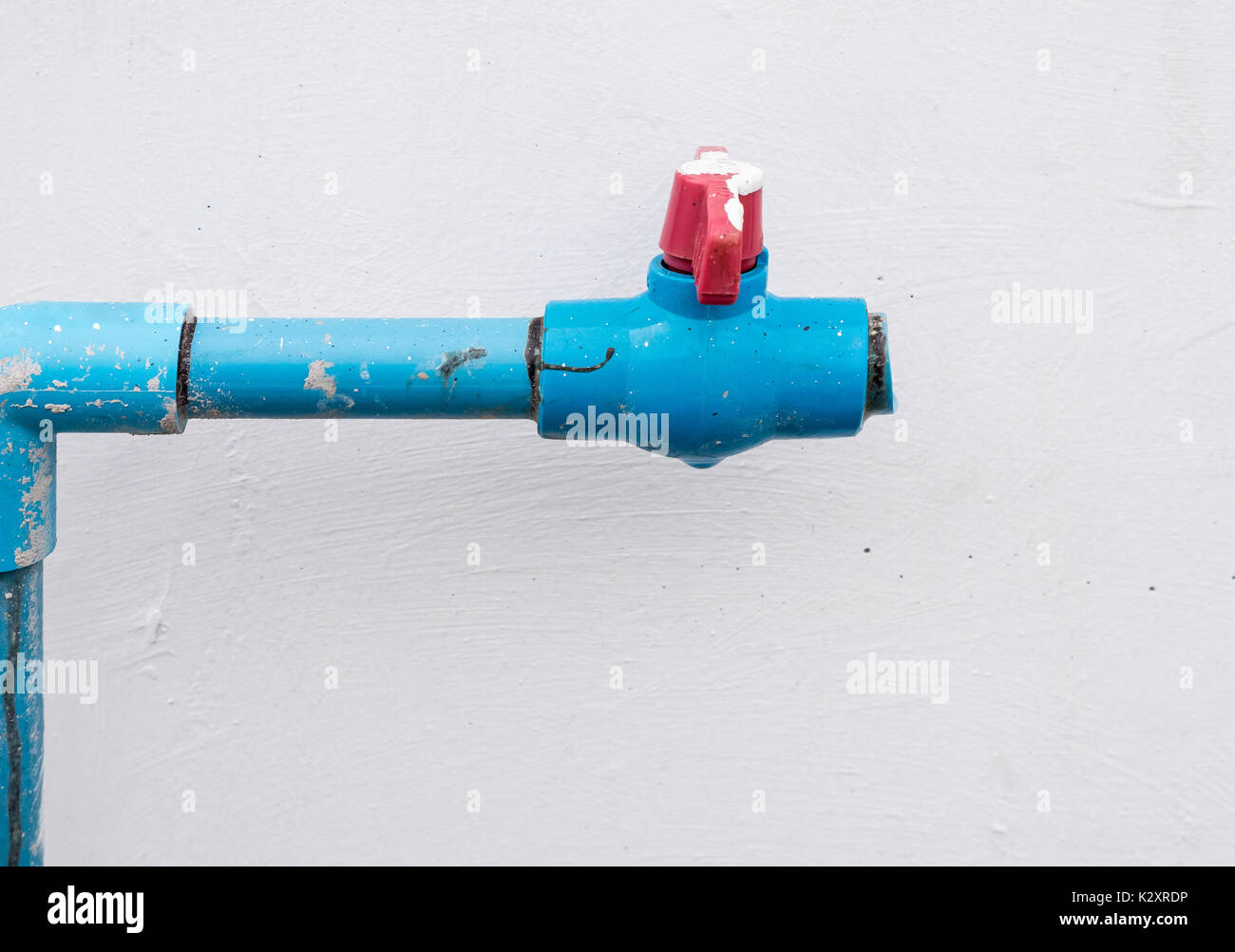 Tuyau PVC eau avec la valve en plastique rouge qui casse l'installation de  mur près de la maison Photo Stock - Alamy