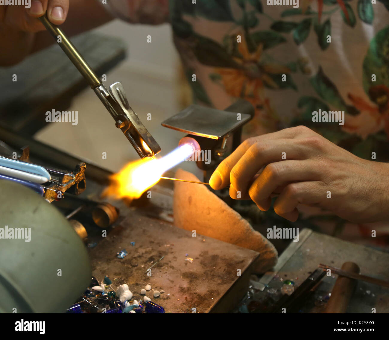 Alors que la fonte et le façonnage verrier le verre avec une flamme à très haute température dans son laboratoire artisan en Italie Banque D'Images