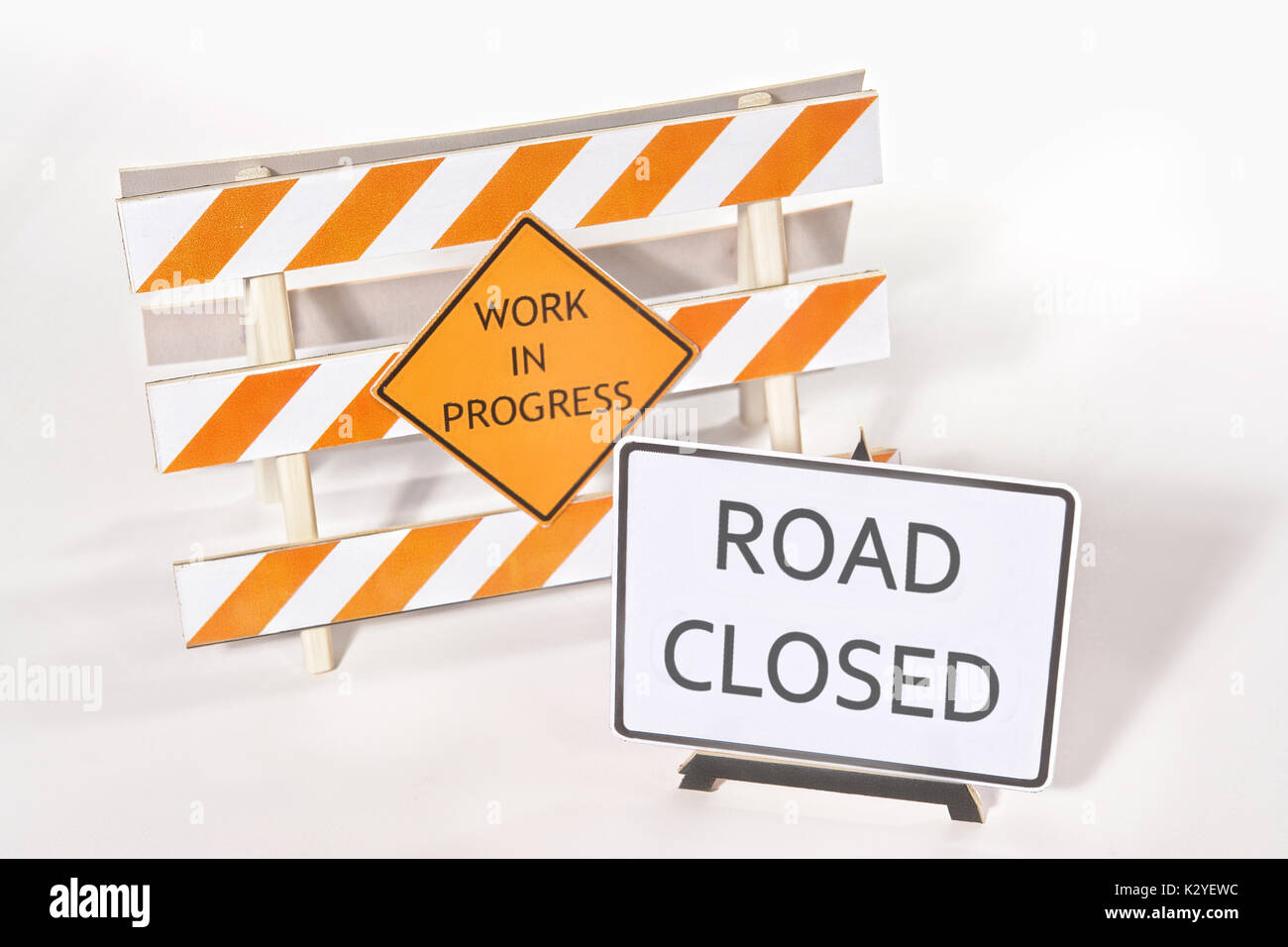 Les barrières d'avertissement de construction avec les travaux en cours et les signes route fermée sur fond blanc Banque D'Images