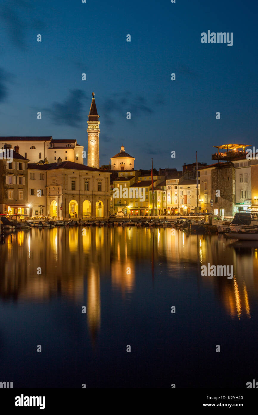 Piran, petite et unique ville vénitienne sur la côte slovène avec son petit port dans la chaude soirée d'été et une réflexion de la mer côtière. Banque D'Images