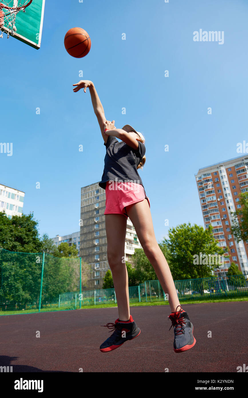 Joueur de basket-ball fille lance la balle vers le haut Banque D'Images