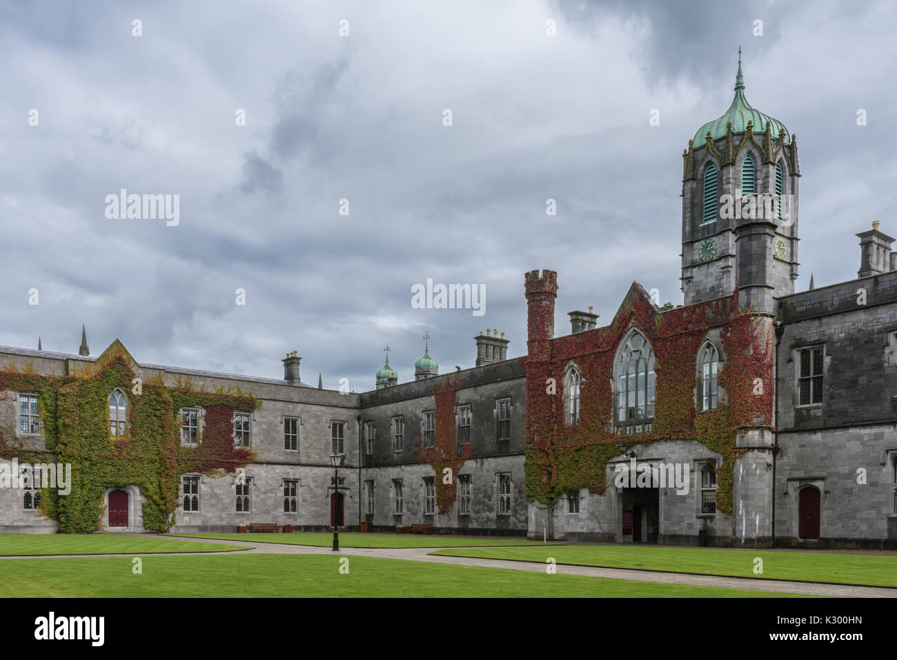 Galway, Irlande - Août 5, 2017 : partie de quadrilatère historique sur le campus de l'Université nationale d'Irlande. Bloc d'entrée couverte de lierre avec tour de l'horloge Banque D'Images