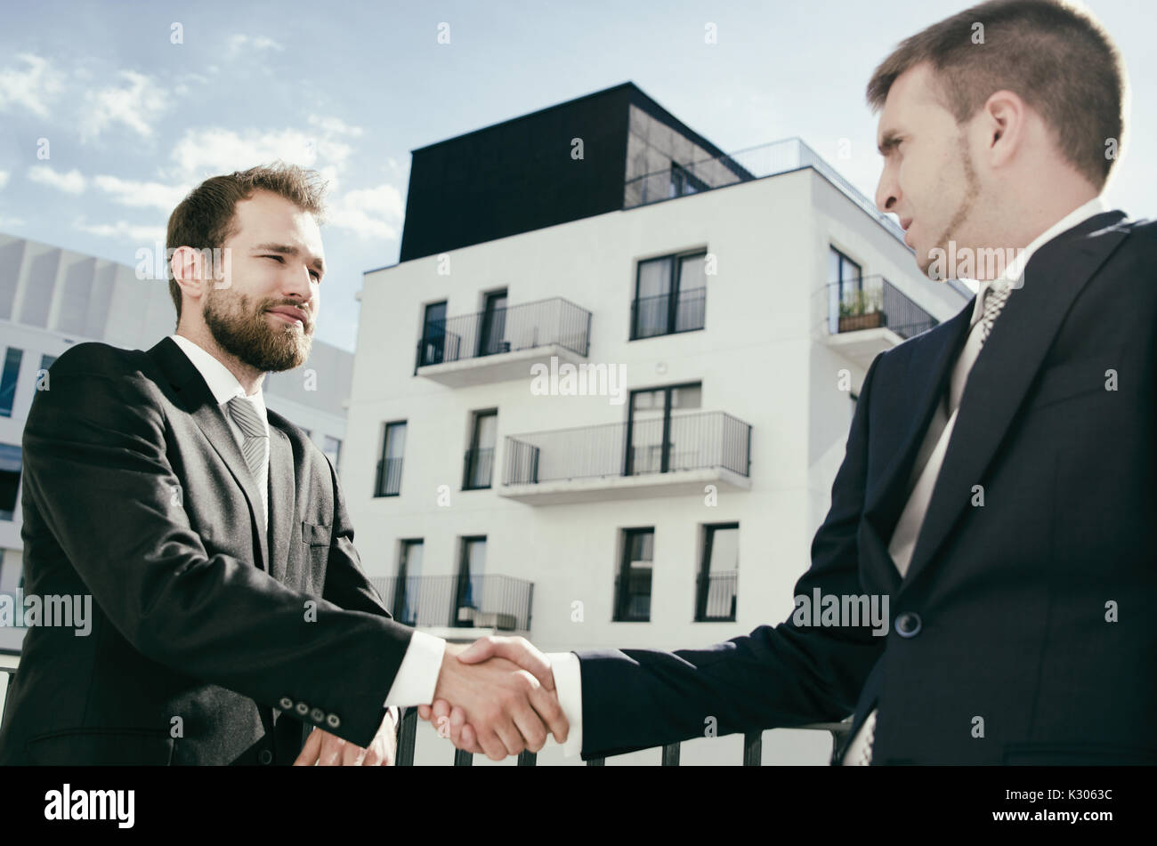 Deux hommes sont debout sur le balcon et se serrer la main. Appartement d'achat du client ou investisseur Banque D'Images