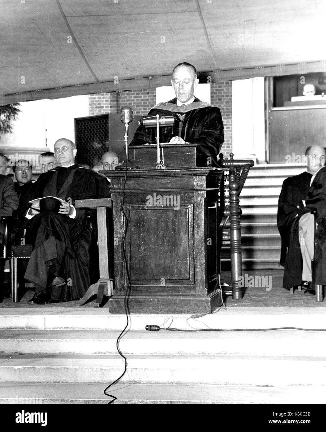 Au jour dit, Président de l'Université Johns Hopkins, Detlev Bronk, Wulf est à un podium sur la scène s'adressant à la foule pendant la cérémonie en plein air, avec les professeurs et le personnel assis sur la scène de chaque côté, Baltimore, Maryland, le 12 juin 1952. Banque D'Images