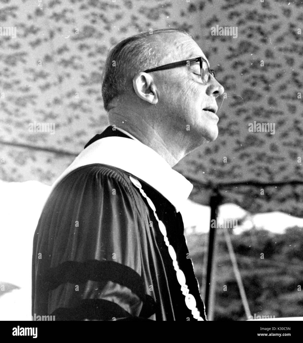 Au jour dit, Président de l'Université Johns Hopkins Milton Stover Eisenhower porte une tenue de diplôme à s'adresser à la foule d'un podium, son profil visible et ses yeux fermés, Baltimore, Maryland, le 13 juin 1967. Banque D'Images
