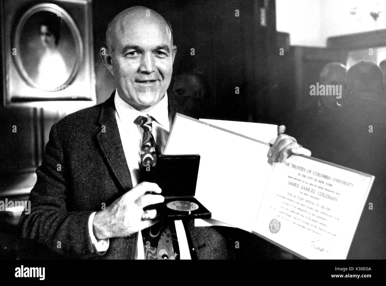 Théoricien et professeur de sociologie à l'Université Johns Hopkins James Samuel Coleman tenant une médaille et un certificat, 1965. Banque D'Images