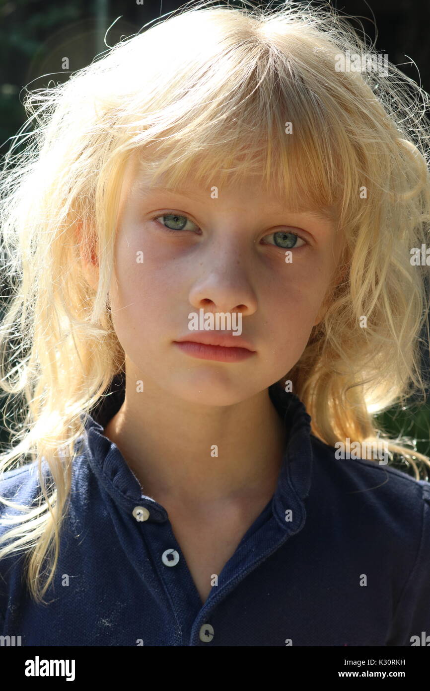 Portrait d'une fille blonde avec des yeux bleus tristes Banque D'Images