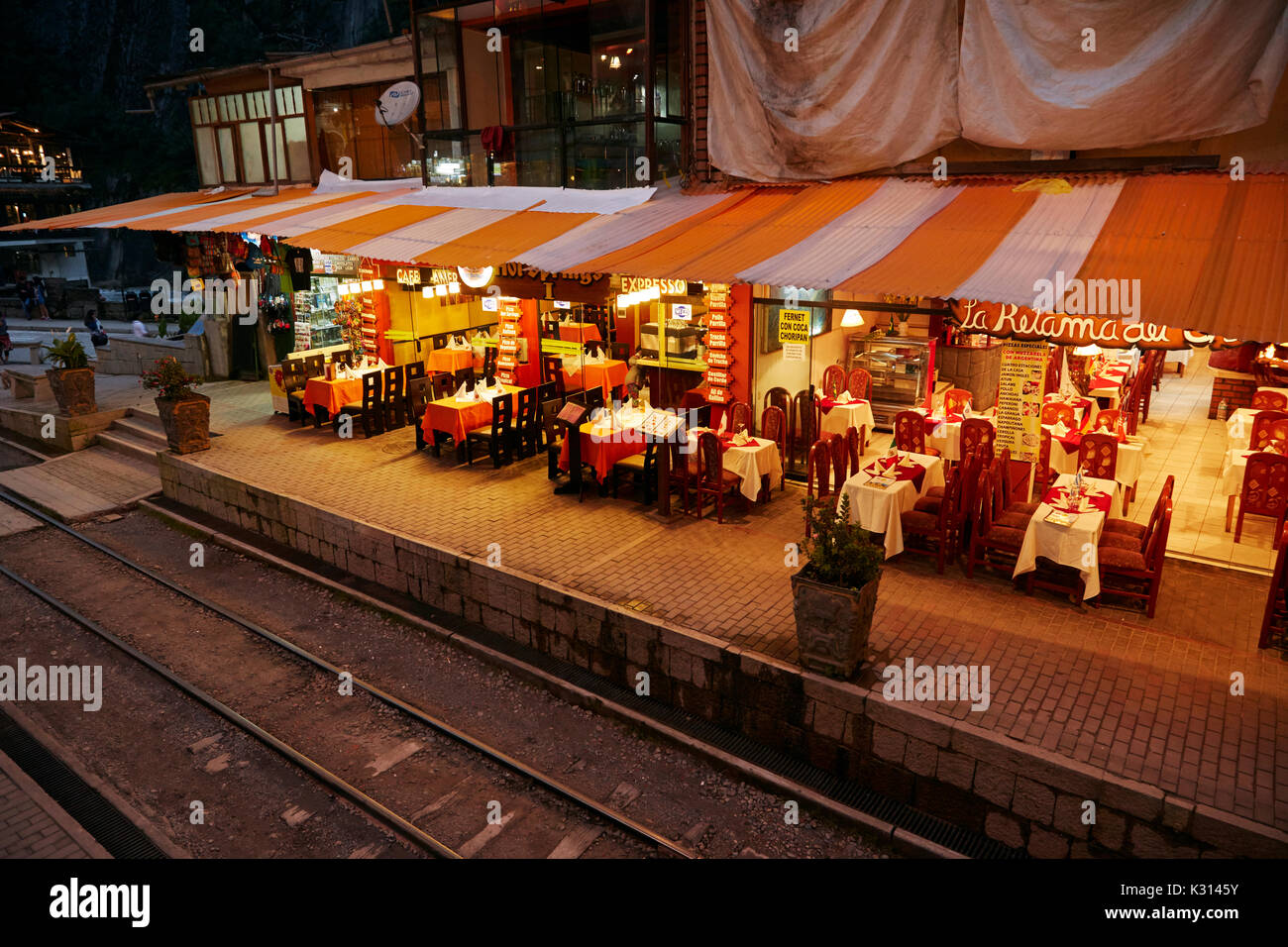 Les lignes de chemin de fer au milieu de restaurants à Aguas Calientes au crépuscule, la Vallée Sacrée, le Pérou, Amérique du Sud Banque D'Images