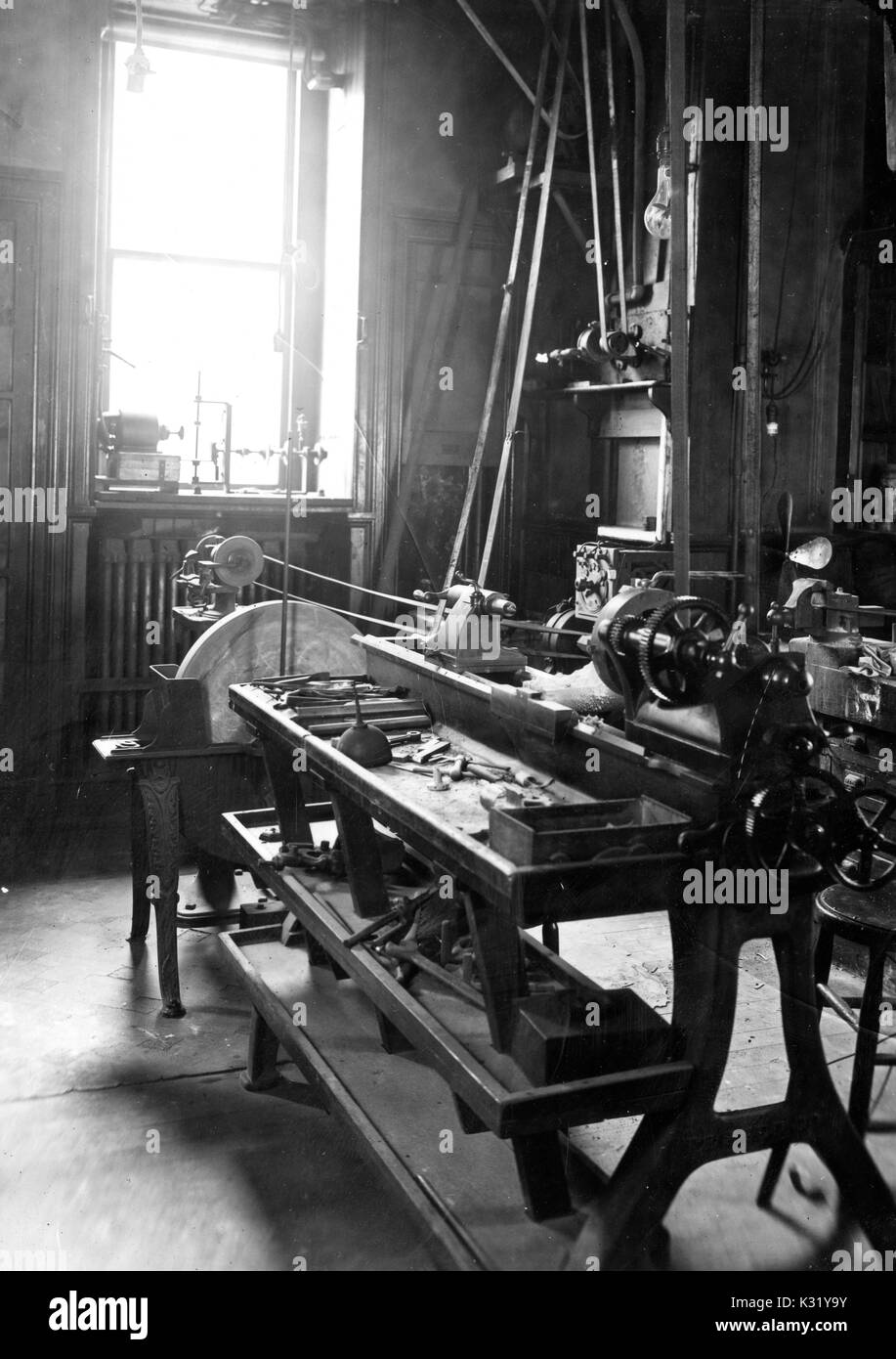 Gris photo de l'intérieur du troisième étage machine shop où le célèbre chimiste Harmon Northrop Morse a travaillé, à l'intérieur du bâtiment de chimie au vieux campus de l'Université Johns Hopkins, montrant le gros équipement couvrant les tables en désordre, Baltimore, Maryland, 1918. Banque D'Images
