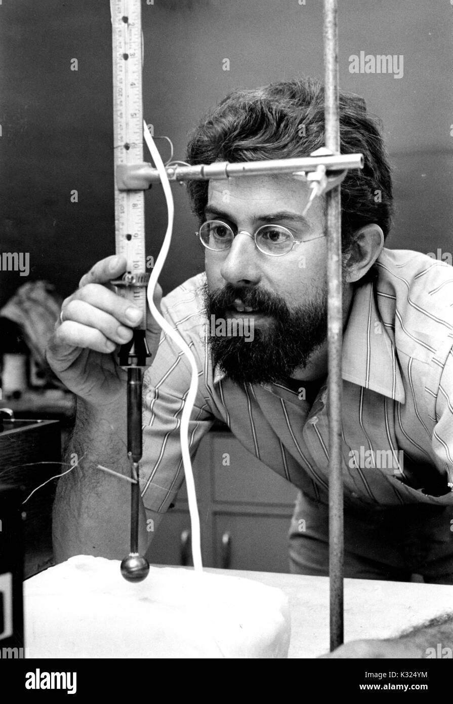Dans un laboratoire à l'Université Johns Hopkins, Bruce D. Marsh -- professeur de sciences de la Terre et des planètes -- se penche alors à préparer une expérience impliquant une règle et d'un dispositif rotatif, regarder attentivement à travers les verres, Baltimore, Maryland, 1975. Banque D'Images