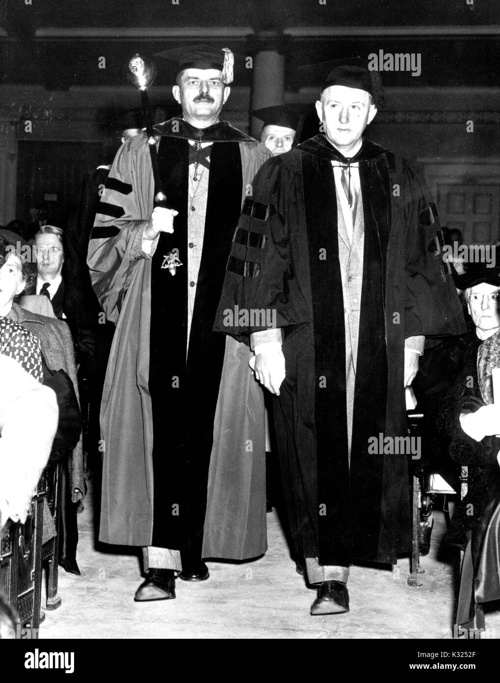 Sur la Journée de commémoration, Sidney Painter -- un érudit médiéval à l'Université Johns Hopkins -- conduit la procession tout en maintenant la masse, aux côtés de Woodward C Vann -- United States historien à l'Université Johns Hopkins -- porter des robes universitaires, tandis que les clients restent assis de chaque côté, Baltimore, Maryland, le 22 février 1954. Banque D'Images