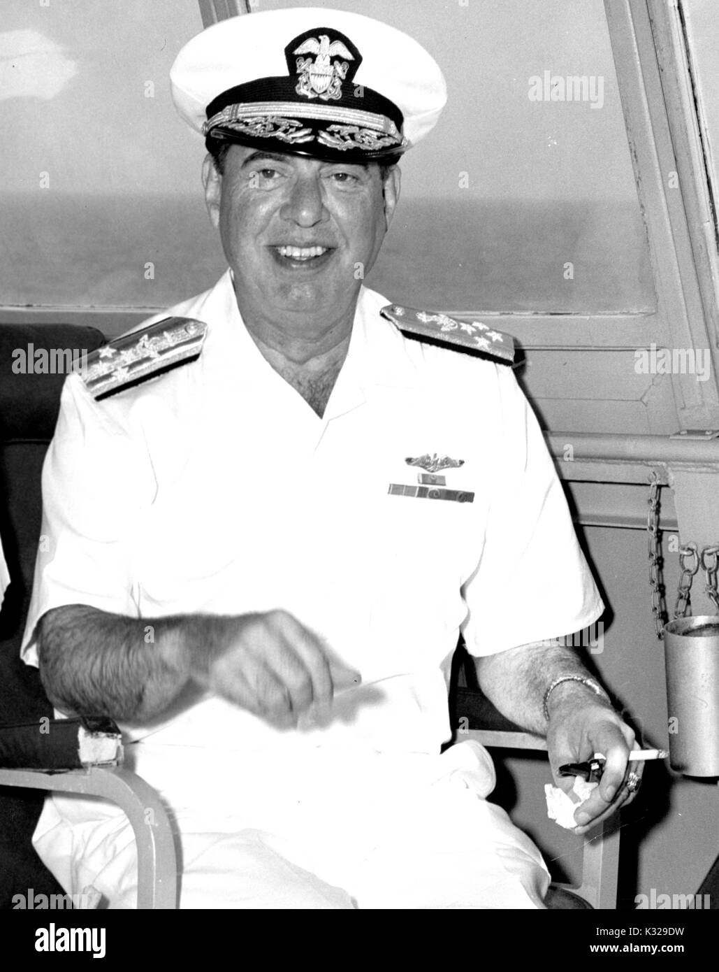 Portrait de Robert Lee Dennison, officier de la marine américaine et l'assistant du président Harry Truman, souriant et fumeurs en uniforme sur un bâtiment de guerre, 1963. Banque D'Images