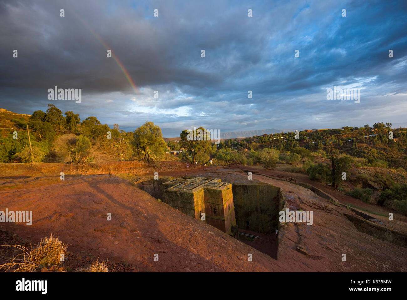 Dans un arc-en-ciel orageux gris, comme golden sunset light attrape le haut de l'antique Sculpté en pierre Bet Giyorgis (Église de Saint Georges), Lalibela, Éthiopie Banque D'Images