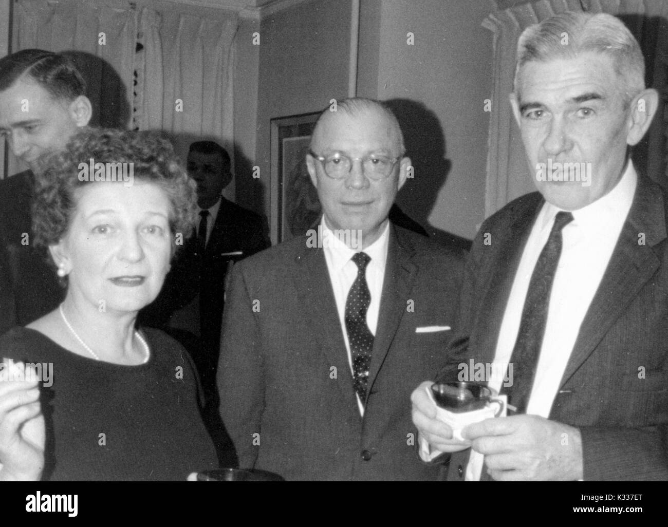 Administrateur de l'éducation et président de l'Université Johns Hopkins Milton Eisenhower s'élève entre un homme non identifié et la femme au cours d'une fonction, l'université de Baltimore, Maryland, 1960. Banque D'Images